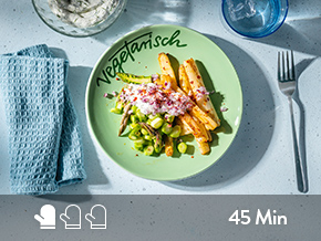 Spargelsalat vegetarisch serviert auf einem grünen Teller. 