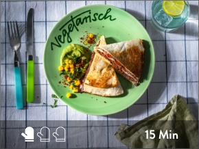 Vegetarischer Wrap serviert auf grünem Teller. 