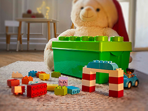 Verschiedene Legosteine liegen auf einem Kinderzimmerteppich.