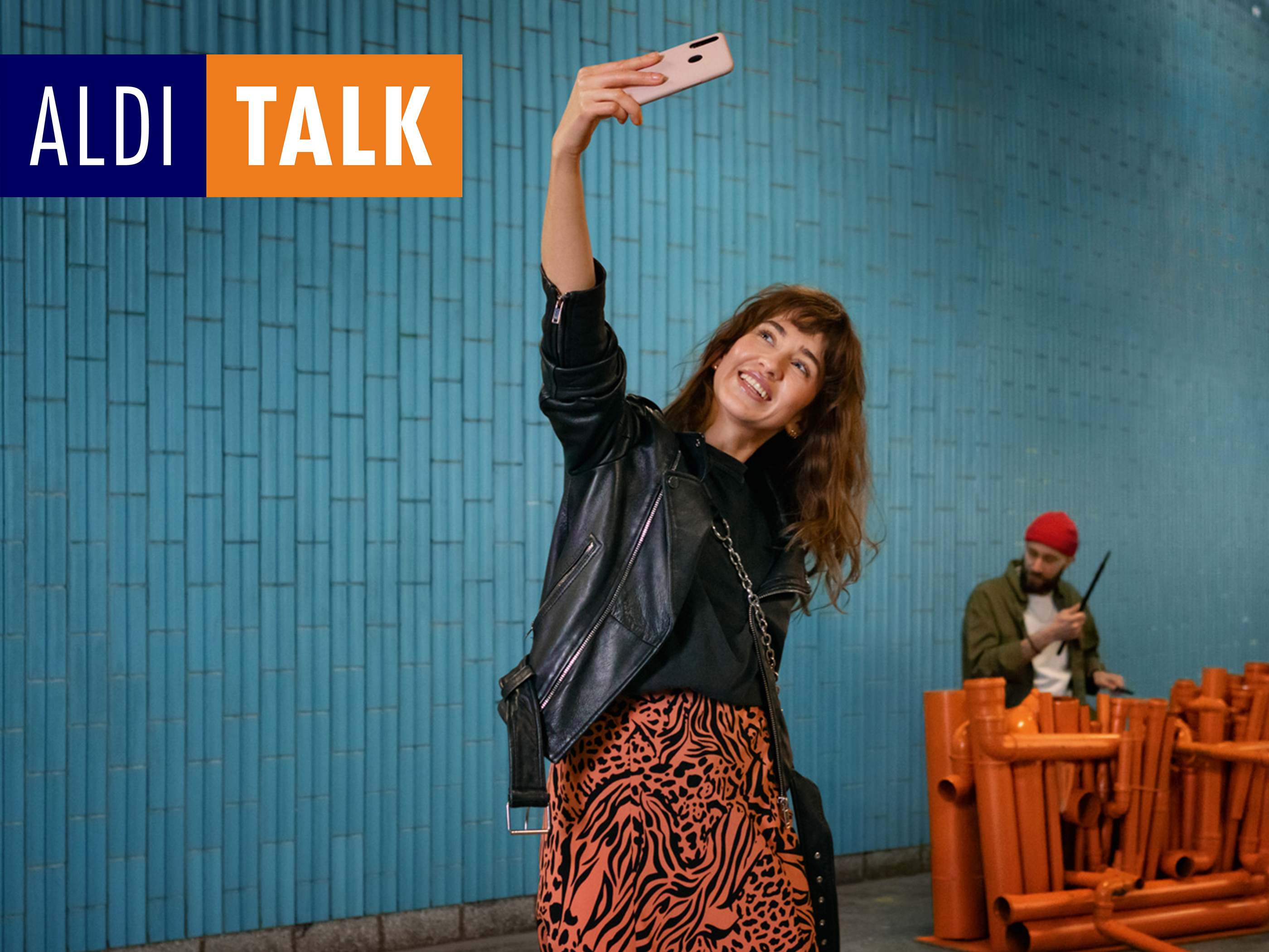 ALDI TALK. Frau hält Handy in der Hand und macht ein Selfie von sich.