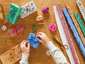 Geschenke werden mit Geschenkpapier eingewickelt.